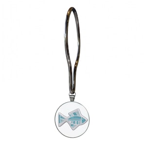 May include: A silver-toned metal shower curtain hook featuring a circular pendant. The pendant displays a white and light blue graphic of a fish with striped fin details. The hook has a long, slender, oval-shaped loop for attachment to a rod.