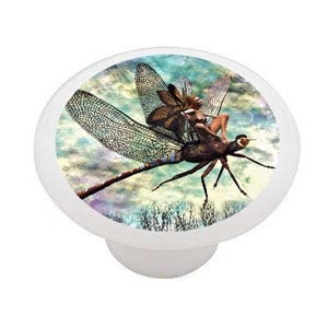 May include: A ceramic knob with a whimsical image of a fairy riding a dragonfly against a cloudy sky background.