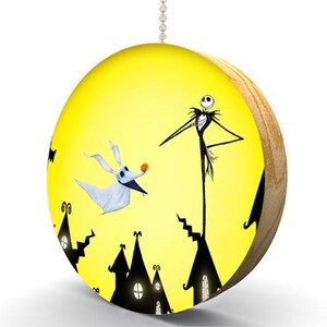 May include: A yellow pull chain with a round wooden disc featuring a black silhouette of Jack Skellington from The Nightmare Before Christmas, standing on a rooftop with his dog Zero, against a yellow moon background.