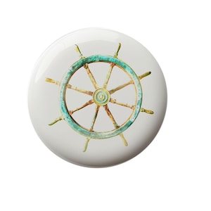 May include: A white round button with a blue and brown wooden ship's wheel with eight spokes.