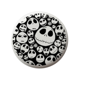 May include: Black and white button with a repeating pattern of Jack Skellington's face from the Nightmare Before Christmas.