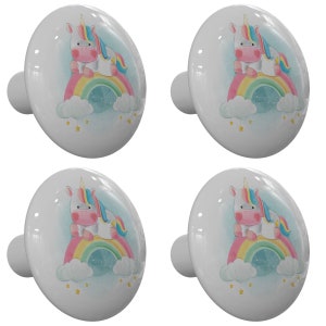 May include: Four white ceramic cabinet knobs with a unicorn sitting on a rainbow design. The unicorn is pink with a blue and yellow mane and tail. The rainbow is pink, orange, yellow, green, blue, and purple. The background is light blue with white clouds and yellow stars.
