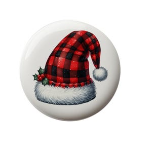 May include: A red and black plaid Santa hat with a white fur trim and green holly leaves.