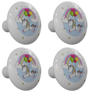 May include: Four white ceramic cabinet knobs with a whimsical unicorn design. Each knob features a unicorn with a rainbow, balloons, and stars. The knobs are perfect for adding a touch of fantasy to furniture.