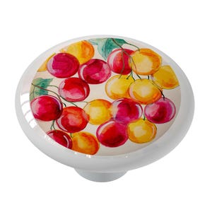 May include: A ceramic knob with a watercolor painting of red, yellow, and orange cherries on a branch. The cherries are clustered together and have a realistic look.