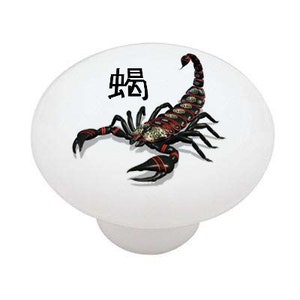 May include: A white ceramic knob with a black and red scorpion design and the Chinese character for scorpion, "蝎", in black.