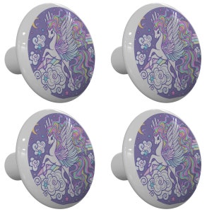May include: Set of four ceramic cabinet knobs featuring a whimsical unicorn with rainbow mane and wings flying through clouds on a purple background with stars.