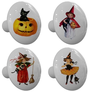 May include: Set of four white ceramic cabinet knobs with Halloween-themed illustrations. Designs include a black cat in a jack-o'-lantern, a child in a witch costume, and a child with a black cat and broom.