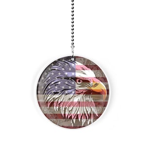 May include: A white ceiling fan pull with a red, white, and blue American flag design featuring a bald eagle's head.