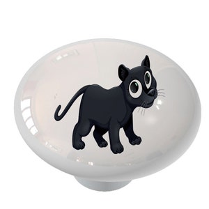 May include: A white ceramic knob with a cartoon black panther illustration. The panther has large eyes and is looking to the right.