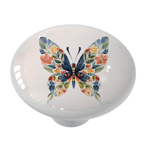 May include: A white ceramic knob with a colorful butterfly design. The butterfly has blue, yellow, orange, and green wings with floral details.