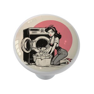 May include: A vintage-style illustration of a woman putting laundry into a washing machine. The woman is wearing a red headband and a dress. The washing machine is white with a black door. The background is a pink circle.