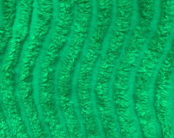 Puede incluir: Primer plano de una tela verde brillante con un patrón texturizado y acanalado. Las crestas corren verticalmente a través de la imagen, creando un efecto ondulado. La tela parece suave y afelpada, con una textura ligeramente borrosa.