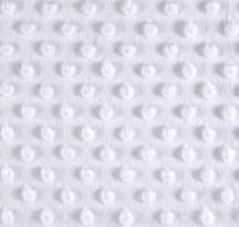 Puede incluir: Tela blanca con un patr&oacute;n texturizado de peque&ntilde;os c&iacute;rculos en relieve.
