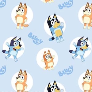 May include: Light blue fabric featuring a repeating pattern of cartoon dogs in various poses, each within a white circle. The word "Bluey" is written in blue script across the fabric. The dogs are in shades of orange and blue.