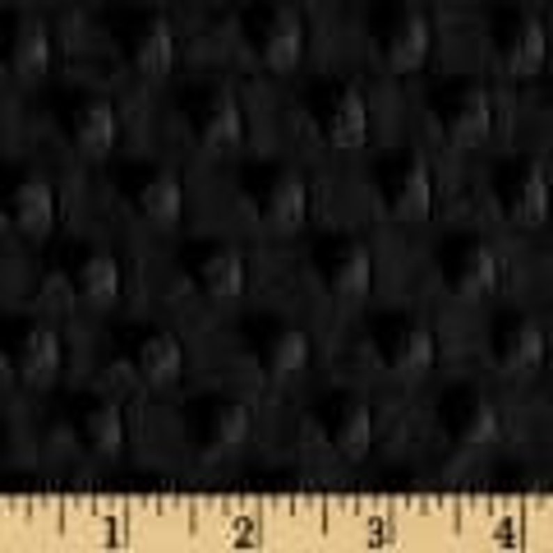May include: Black fabric with a textured, raised dot pattern. The pattern is evenly spaced across the material. A ruler is shown along the bottom, with measurements in inches.