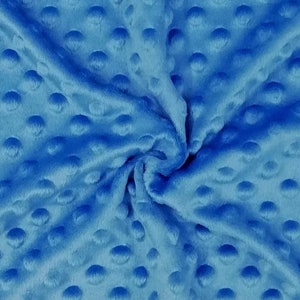 K&ouml;nnte beinhalten: Nahaufnahme eines weichen, blauen Stoffes mit einem strukturierten, gepunkteten Muster. Der Stoff ist zerknittert und gefaltet, wodurch die Textur des Materials sichtbar wird.