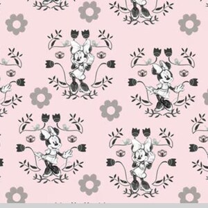 May include: A pink fabric with a repeating pattern of a black and white cartoon mouse wearing a dress and bow. The mouse is surrounded by black floral designs and grey flowers.