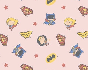 Puede incluir: Tela rosa con un patrón repetido de superhéroes de dibujos animados, incluyendo Superman, Wonder Woman y Batman. El patrón también incluye estrellas y los logotipos de cada superhéroe.