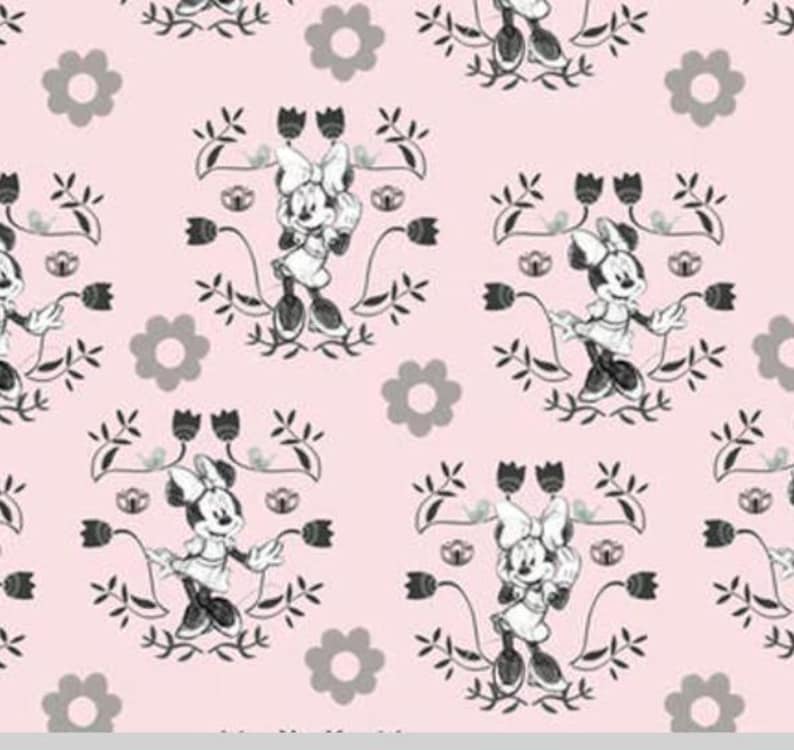 May include: A pink fabric with a repeating pattern of a black and white cartoon mouse wearing a dress and bow, surrounded by black floral designs. The background is a light pink colour.