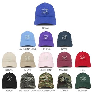 May include: A collection of 12 baseball caps in various colors and patterns. The caps feature a white embroidered bicycle with the text "Let's Ride" above it. The colors include royal blue, carolina blue, purple, navy, stone, khaki, light pink, maroon, red, black, digital night camo, digital green camo, camo, and hunter.