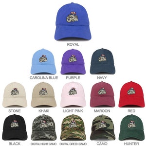 May include: A collection of 12 baseball caps featuring a cartoon elephant wearing a red, white, and blue hat. The caps are available in a variety of colors, including royal blue, carolina blue, purple, navy, stone, khaki, light pink, maroon, red, black, digital night camo, digital green camo, camo, and hunter.