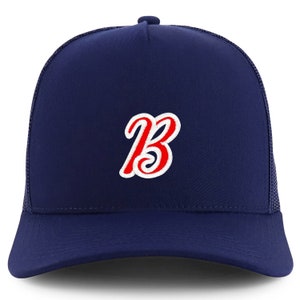 May include: A navy blue trucker hat with a red and white embroidered letter "B" on the front.