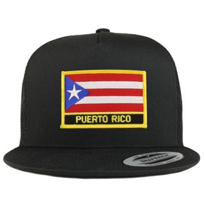 Könnte beinhalten: Schwarze Snapback-Kappe mit einem Patch der puerto-ricanischen Flagge. Der Patch zeigt ein blaues Dreieck mit einem weißen Stern, rot-weiße Streifen und den Text "PUERTO RICO" in gelben Buchstaben.