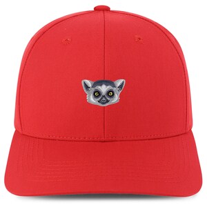Può includere: Cappellino da baseball rosso con un viso di lemuri ricamato sul davanti.