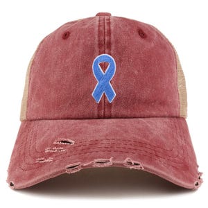 Könnte beinhalten: Eine verwaschene bordeauxfarbene Baseballkappe mit einem hellbraunen Mesh-Rücken. Auf der Vorderseite der Kappe ist eine hellblaue Schleife aufgestickt. Die Kappe hat einen Used-Look mit Löchern.