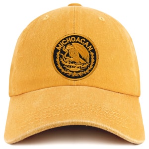 Può includere: Un cappello da baseball giallo con una toppa ricamata in nero e oro che presenta lo stemma messicano e il testo "MICHOACAN".
