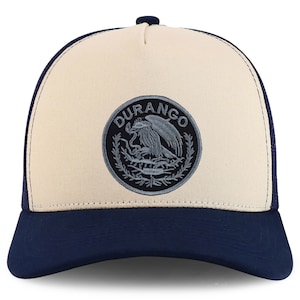 Könnte beinhalten: Eine beige und marineblaue Trucker-Kappe mit einem schwarzen und grauen gestickten Aufnäher, auf dem "DURANGO" steht und ein stilisierter Adler abgebildet ist.