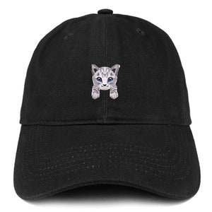 以下が含まれることがあります： 前面にグレーと白の猫が刺繍された黒い野球帽。猫は青い目をしており、視聴者を見ている。