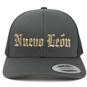 May include: A dark gray trucker hat with a black mesh back. The hat has a gold embroidered inscription that reads "Nuevo Leon".