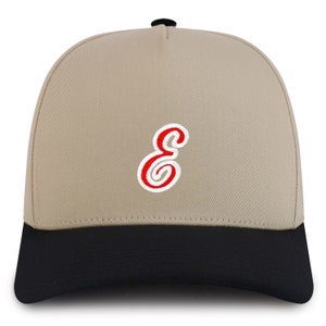 May include: A beige and black baseball cap with a red and white embroidered letter "E" on the front.
