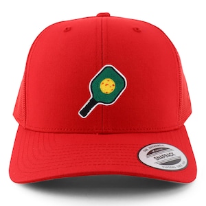 May include: Red mesh trucker hat with a green and yellow embroidered pickleball paddle design. The hat has a black bill and a white snap closure. The text "THE AUTHENTIC SNAPBACK" is printed on a black label on the back of the hat.
