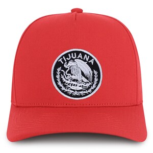 May include: Red baseball cap with a black and white embroidered patch that says "TIJUANA" and features a stylized eagle.