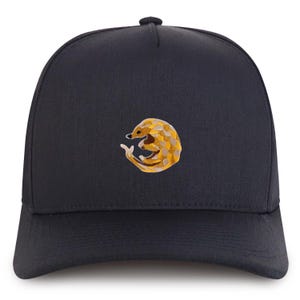 May include: A black baseball cap with an embroidered yellow and brown pangolin design.