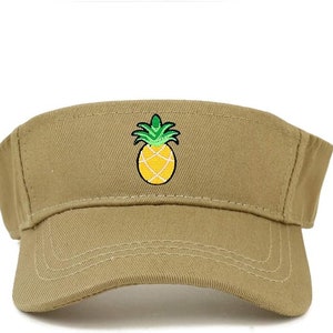 May include: A khaki visor with an embroidered pineapple design. The pineapple is yellow with green leaves.