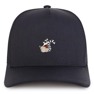 Könnte beinhalten: Eine schwarze Baseballkappe mit einem gestickten Bild eines Lemurs.