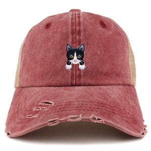 May include: A distressed burgundy baseball cap with a mesh back and a cat embroidery. The cat is black and white with yellow eyes. The cap has a pre-worn look with distressed holes.