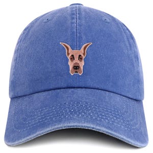 Può includere: Cappellino da baseball blu con un ricamo del muso di un cane Alano. Il cappellino è realizzato in morbido cotone lavato e presenta una visiera curva e un cinturino regolabile. Il muso del cane è marrone con dettagli neri e occhi rossi.