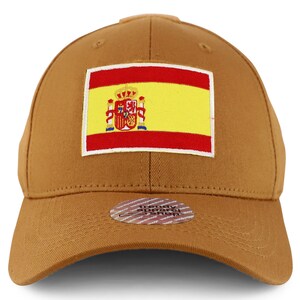 Puede incluir: Una gorra de béisbol marrón con un parche bordado de la bandera española en la parte delantera. El parche presenta el escudo de armas español y los colores rojo y amarillo. La gorra tiene una correa ajustable marrón con una hebilla de metal.
