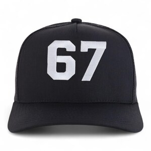 May include: Black trucker hat with a white embroidered "67" on the front. The hat features a mesh back and a curved brim. The number is in a bold, block style.