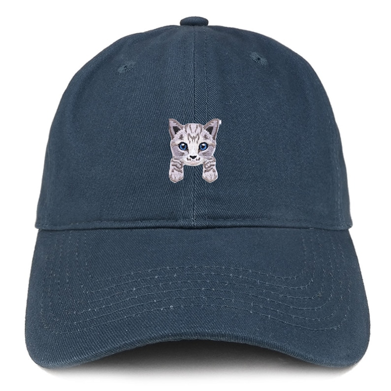 以下が含まれることがあります： 青い野球帽に、グレーと白の猫の刺繍が施されています。猫は青い目をしています。カメラを見て、前足を上げています。