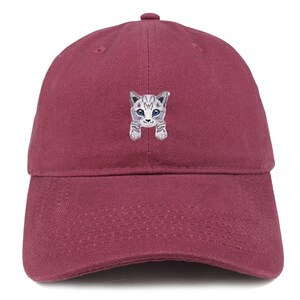 以下が含まれることがあります： 青い目をした灰色と白の猫の刺繍が施された、マルーンのベースボールキャップです。
