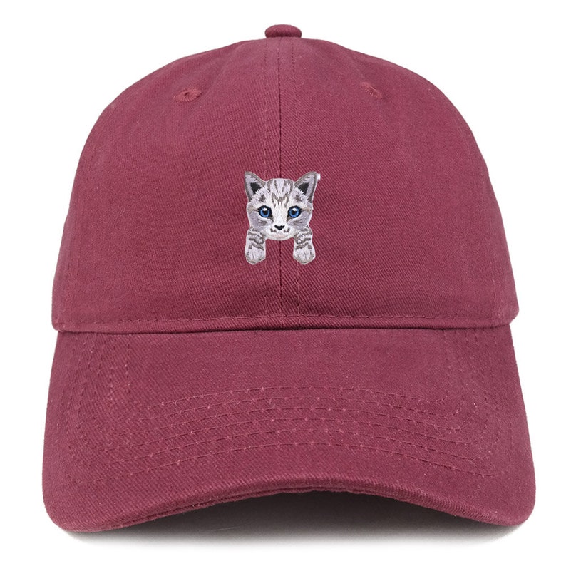 以下が含まれることがあります： 青い目をした灰色と白の猫の刺繍が施された、マルーンのベースボールキャップです。