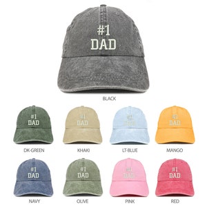 以下が含まれることがあります： 10色の異なる野球帽子のセット。それぞれに「#1 DAD」という文字が白で刺繍されています。帽子は、使い古したデニム生地で作られています。