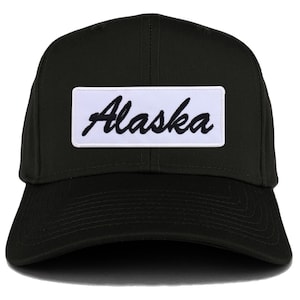 Può includere: Cappellino da baseball nero con una toppa bianca che dice "Alaska" in un font corsivo nero.