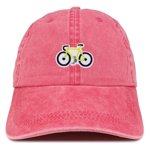 May include: A red baseball cap featuring a yellow bicycle emblem. The bicycle has black wheels and a white outline. The cap is made of a soft, washed cotton material.